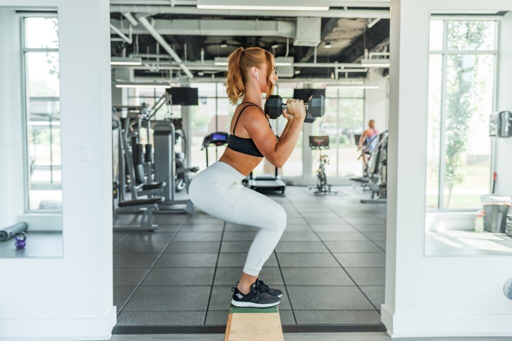 woman performing a dumbbell goblet squat - leg workout for women